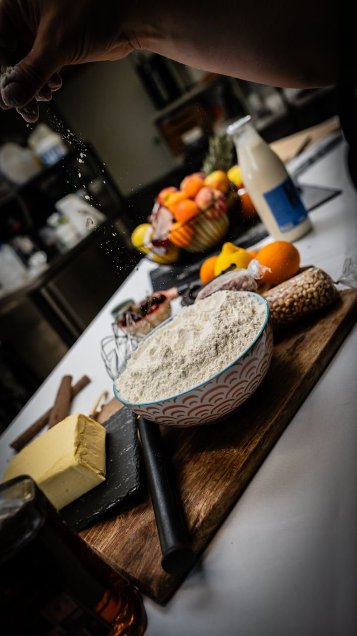 Geste de pâtissier saupoudrant de la farine, photo culinaire pour Le Petit Luce