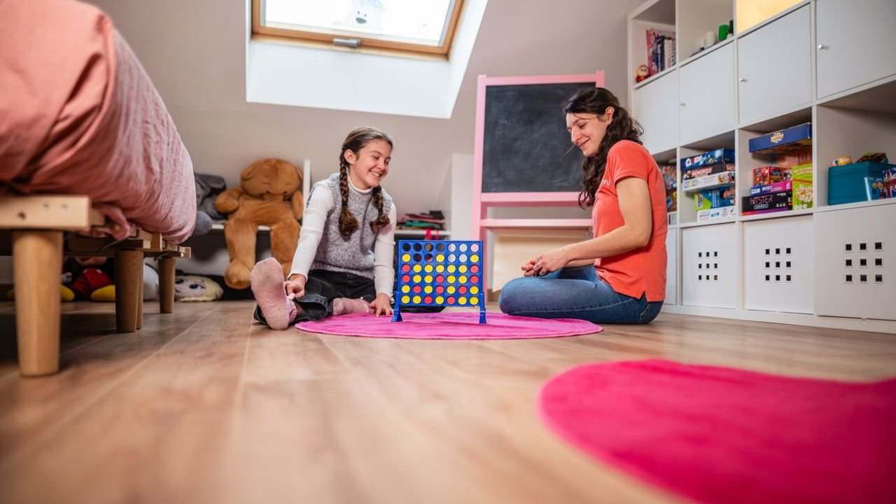 Intervenante Weezmi et une enfant souriante dans une chambre, photo services à domicile